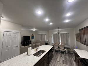 Kitchen featuring recessed lighting, a textured ceiling, a sink, and dark wood-type flooring