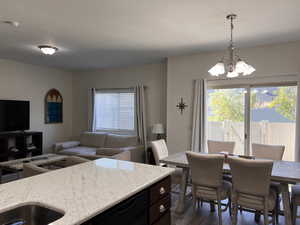 Dining area featuring an inviting chandelier and dark wood-type flooring