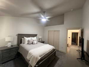 Bedroom featuring a closet, dark colored carpet, baseboards, high vaulted ceiling, and a ceiling fan