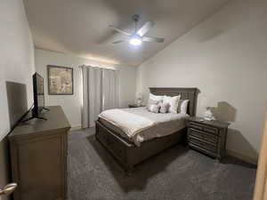 Bedroom featuring dark carpet, a ceiling fan, baseboards, and lofted ceiling