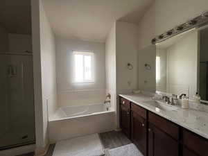 Full bathroom with a garden tub, vanity, wood finished floors, and a shower stall