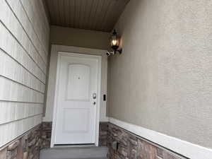 Property entrance with stucco siding and stone siding
