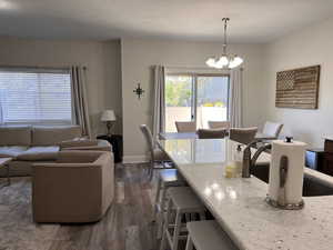 Dining area with baseboards, a chandelier, and dark wood-style floors