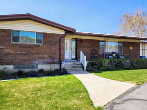 View of front of property with brick siding and a front lawn