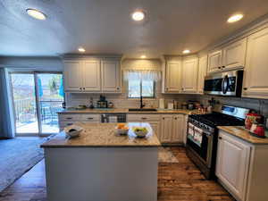 Kitchen featuring a sink, a healthy amount of sunlight, hardwood / wood-style floors, and stainless steel appliances