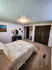 Bedroom featuring two closets, a textured ceiling, baseboards, and visible vents