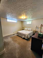 Carpeted bedroom with baseboards, a textured ceiling, and visible vents