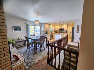 Dining area featuring an inviting chandelier, light wood-style floors, recessed lighting, and a textured ceiling