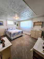 Bedroom with baseboards, multiple windows, dark carpet, and a textured ceiling