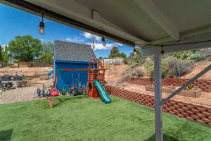 View of play area featuring a lawn and fence