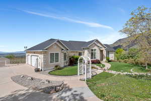 Ranch-style house with a mountain view, stucco siding, driveway, and a front yard