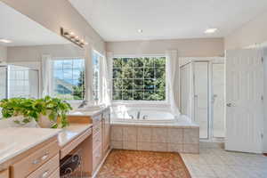 Bathroom with vanity, tile patterned floors, a bath, and a stall shower