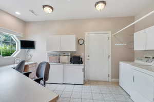 Home office with visible vents, baseboards, washing machine and dryer, and light tile patterned flooring