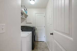 Laundry room with laundry area, baseboards, and washer and dryer