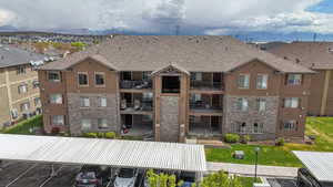 View of building exterior featuring uncovered parking and central air condition unit