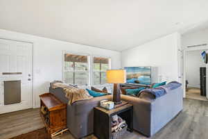 Living room with vaulted ceiling, wood finished floors, and visible vents