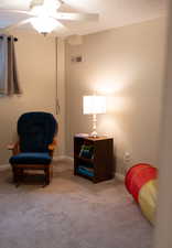 Living area with baseboards, carpet, a ceiling fan, and visible vents