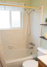 Bathroom featuring vanity, toilet, and shower / bath combination with curtain