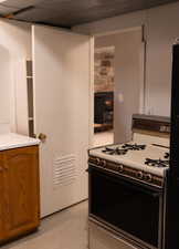 Kitchen with light countertops, brown cabinets, and gas stove