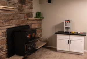Room details featuring baseboards, a wood stove, and carpet