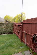 View of yard with fence and a gate
