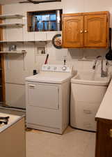 Laundry room featuring light floors, washer / dryer, and cabinet space