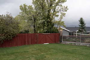 View of yard with fence and a gate
