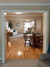 Dining area featuring crown molding, baseboards, baseboard heating, and wood finished floors