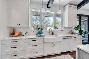 Kitchen featuring a sink, pendant lighting, dark wood-style flooring, and white cabinetry