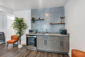 Bar with tasteful backsplash, a sink, a toaster, wine cooler,