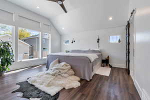 Master Bedroom with visible vents, dark wood finished floors, a barn door, baseboards, and lofted ceiling