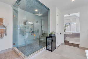 Bathroom with ensuite bathroom, a shower stall, recessed lighting, and beverage cooler
