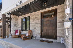 Property entrance with a porch and stone siding