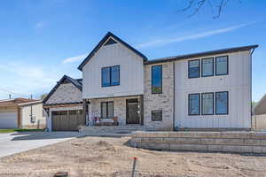 Modern inspired farmhouse featuring covered porch, board and batten siding,