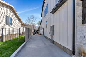View of side of property with board and batten siding, fence, and a yard