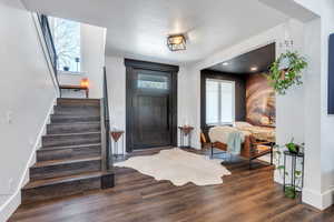 Entrance foyer with stairway, baseboards, and wood finished floors