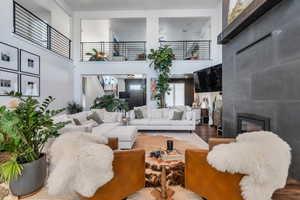 Living room featuring wood finished floors, a high ceiling, and a fireplace