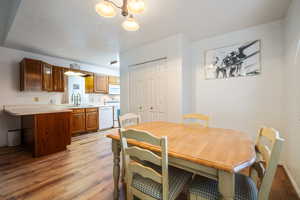 Dining space featuring baseboards, an inviting chandelier, and light wood-type flooring