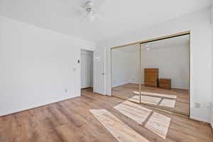 Unfurnished bedroom with baseboards, ceiling fan, and light wood-style floors