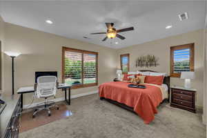 Bedroom with visible vents, baseboards, carpet floors, and multiple windows