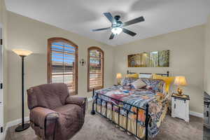 Carpeted bedroom featuring a ceiling fan and baseboards