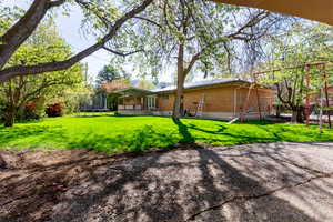 Back of property with a yard, brick exterior