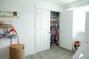 Interior space featuring a closet, carpet flooring, and baseboards