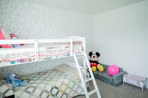 Bedroom featuring carpet flooring and wallpapered walls