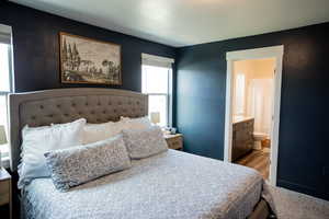 Bedroom with ensuite bathroom and wood finished floors