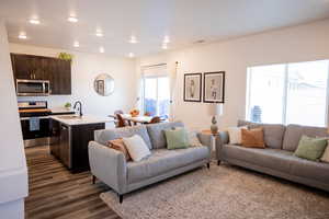 Living area featuring visible vents, recessed lighting, and dark wood-type flooring