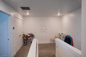Carpeted bedroom with baseboards and visible vents