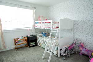 Bedroom featuring carpet floors and wallpapered walls
