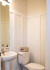 Half bathroom featuring a sink and toilet