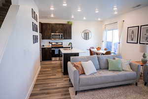 Living room featuring visible vents, recessed lighting, baseboards, and dark wood-style floors
